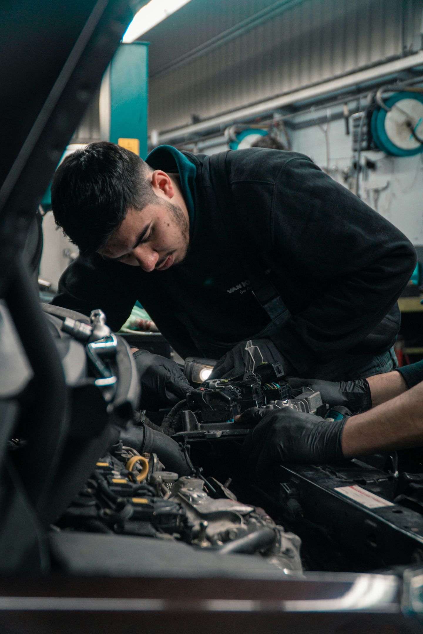 Mecánico revisando el motor de un coche en el taller de Tres Cantos